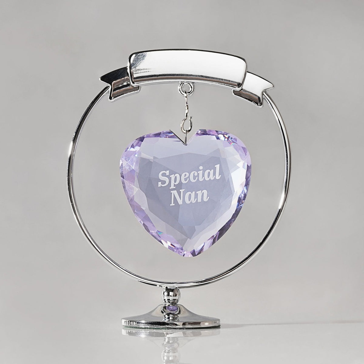 Chrome plated circle and heart decoration with a faceted lilac crystal heart engraved "Special Nan" hanging within a silver ring on a round base, plain light background.