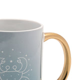 Close-up of a pale blue stoneware mug with a glossy gold oval handle, featuring a white line-drawn Cancer crab design and star details, shown against a white background.