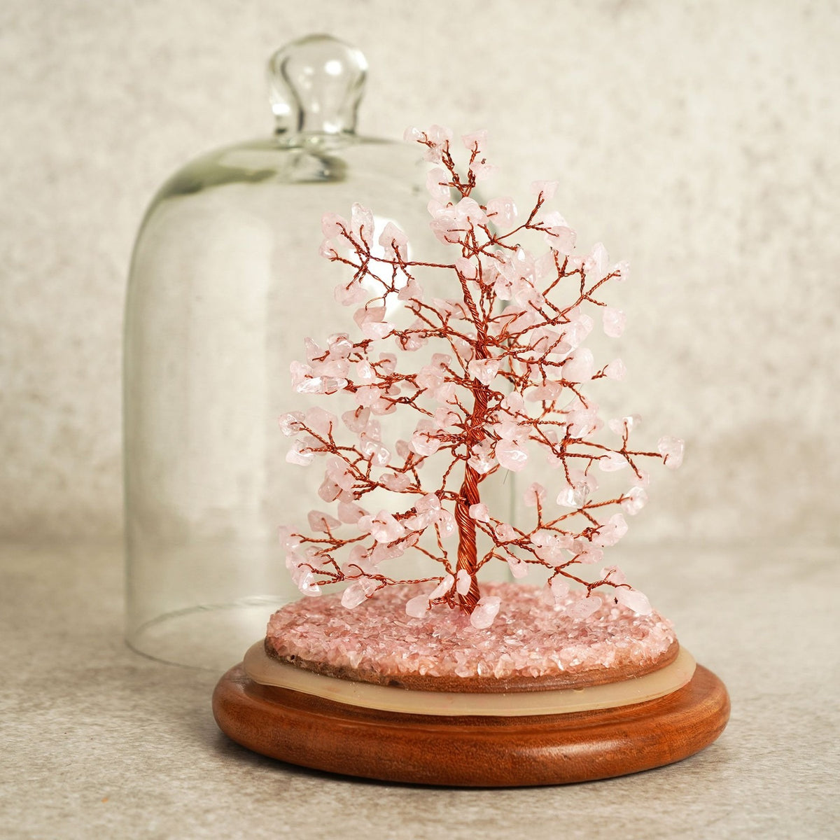 Gemstone Dome Tree figurine with copper-coloured wire branches and 200 pink gemstone beads, pink chip base, under a clear arched glass dome on a round wooden stand.