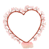 Rose Quartz Heart Tree Figurine with copper-toned wire branches forming an open heart tipped with pink rose quartz chips, set on a chunky rose quartz base.