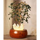 Aventurine LED glow tree decoration with gold wire branches holding green chip leaves over a glowing white crystal cluster set in a round brown wooden base.