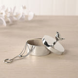 Silverplated Robin Round Trinket Box with lining, lid open and robin finial, holding a necklace and ring, on a light wooden surface with white flowers behind.