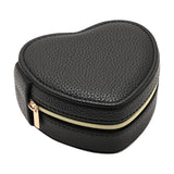 Heart-shaped jewellery box in black pebbled-grain plastic with stitched edges and a gold-tone zip closure, cream lining visible inside, shown on a plain white background.