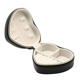 Heart-shaped jewellery box in black pebbled-grain plastic with gold-tone zip, open to show cream lining with earring studs, ring rolls, and divided compartments, on a white background.