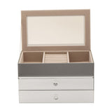 Rectangular mirrored glass jewellery box with two drawers, lid open to reveal a beige lined tray with a central ring roll and divided compartments, set against a plain white background.