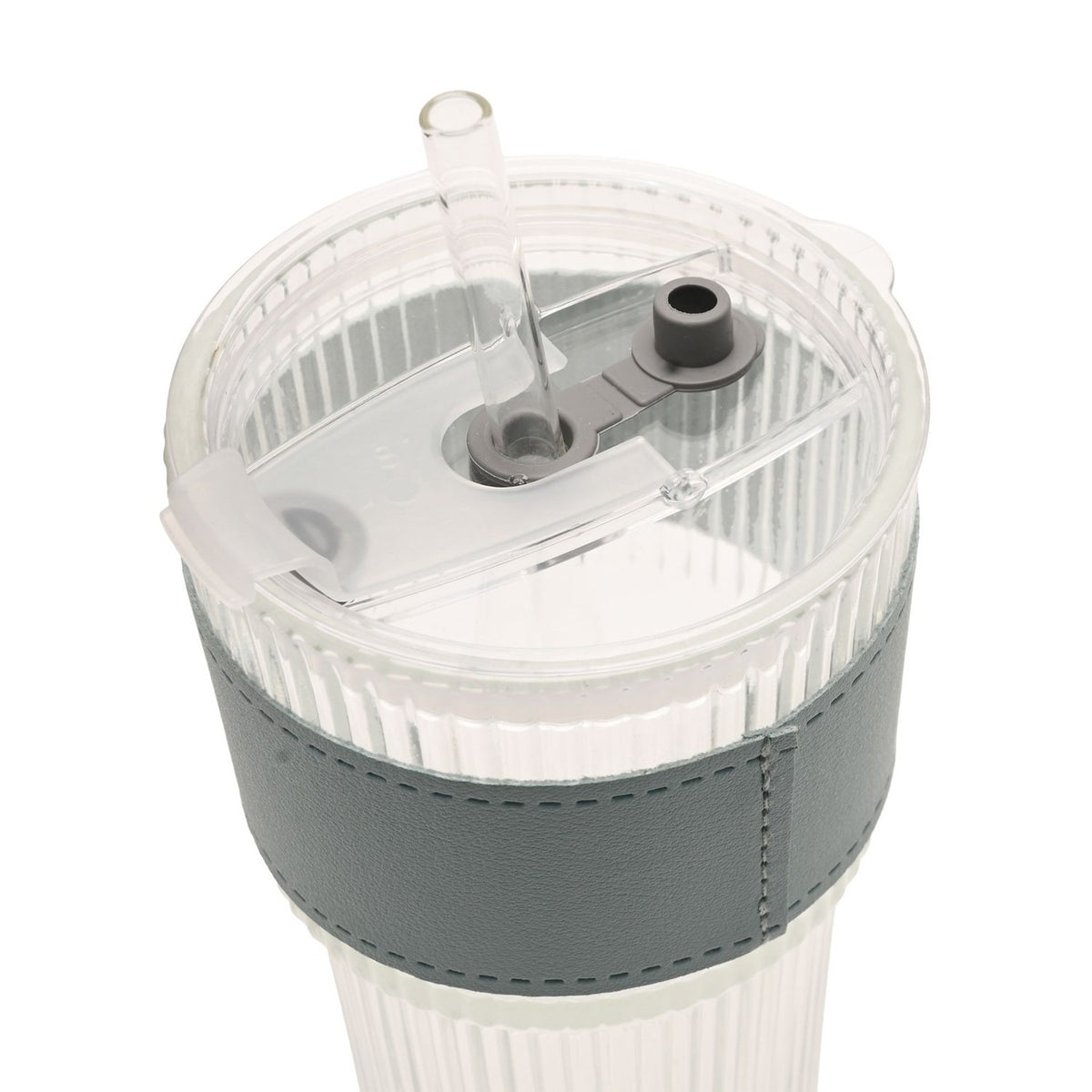 Close-up of a ribbed clear tumbler's flip-top lid with built-in straw opening and clear straw, grey sleeve with stitched edge, on a plain white background.