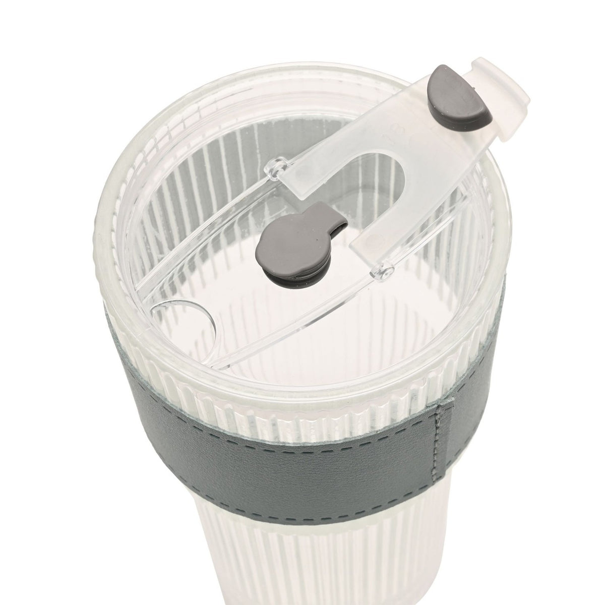 Close-up of a ribbed cold drink tumbler's clear lid with flip-up spout, slide lock and straw opening, grey accents, set on a grey sleeve over the fluted clear body.