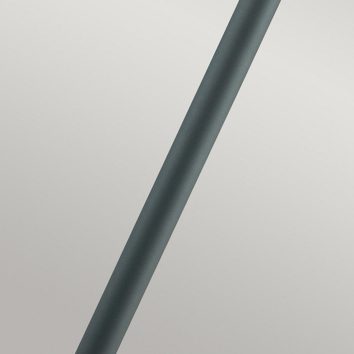 The Stockholm 1 Light Pillar - Black, a sleek cylindrical object embodying Scandinavian design, is positioned diagonally against a plain, light gray background.