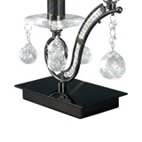 A close-up of the Tara 1 Light Crystal Table Lamp in black chrome, showcasing its shiny rectangular base, curved metallic arm, and dangling clear crystal ornaments that reflect light beautifully.