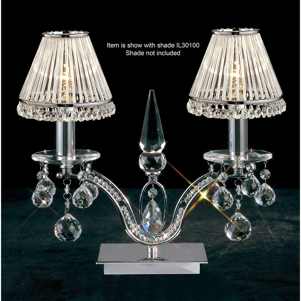 The Tara 2 Light Crystal Table Lamp in polished chrome features two candle-style lights with pleated clear shades (not included) and crystal embellishments hanging from a reflective base.