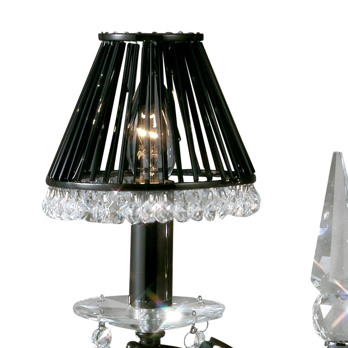 A close-up of the Tara 2 Light Crystal Table Lamp in black chrome without shades, featuring a wire frame and a row of clear crystal-like beads around the base. A faceted crystal ornament on the right enhances its sparkling accents.