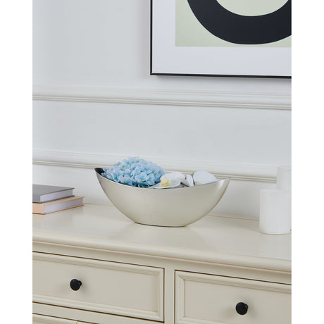 Tazeyol Planter 13cm in Silver, a boat-shaped oval bowl with brushed silver exterior and black interior, shown on a sideboard filled with blue flowers and decorative accents.