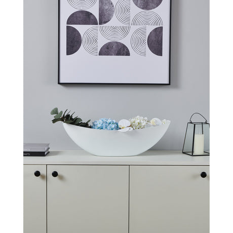White boat-shaped Tazeyol planter, 17.5cm, holding florals on a sideboard beneath framed geometric wall art.