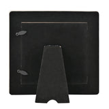 Rear view of the Wildflower Ceramic Photo Frame in white, showing a black velvet-lined back panel, fold-out easel stand, and hanging hooks, on a plain white background.