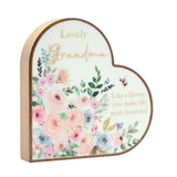 White heart-shaped wooden plaque with brown rim reading Lovely Grandma in gold script, featuring watercolour flowers, a bee, and Like a flower, you make life more beautiful.