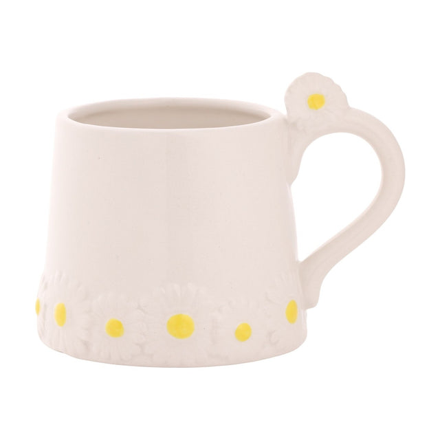 White stoneware mug with a raised daisy band and yellow centres around the base, plus a daisy accent on the curved handle, shown on a plain white background.