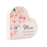 White wooden heart-shaped mini plaque with watercolour pink, peach and blue florals and a bee on the left, reading "Mum, Never forget how LOVED you are" in black script.