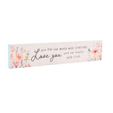Skinny rectangular wooden wall plaque in cream with "Love you" in script and wildflower sprays in peach, coral and lilac at each end, shown on a white background.