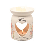 White ceramic wax melt burner with heart cut-out, lit tealight inside, wildflower print, "Loveliest Mummy" text and verse, wax cubes in top bowl, on a plain white background.