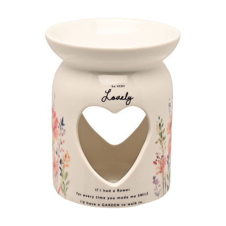 White ceramic wax melt burner with heart cut-out, "So Very Lovely" script, floral wildflower print, and wide top bowl, shown on a plain white background.