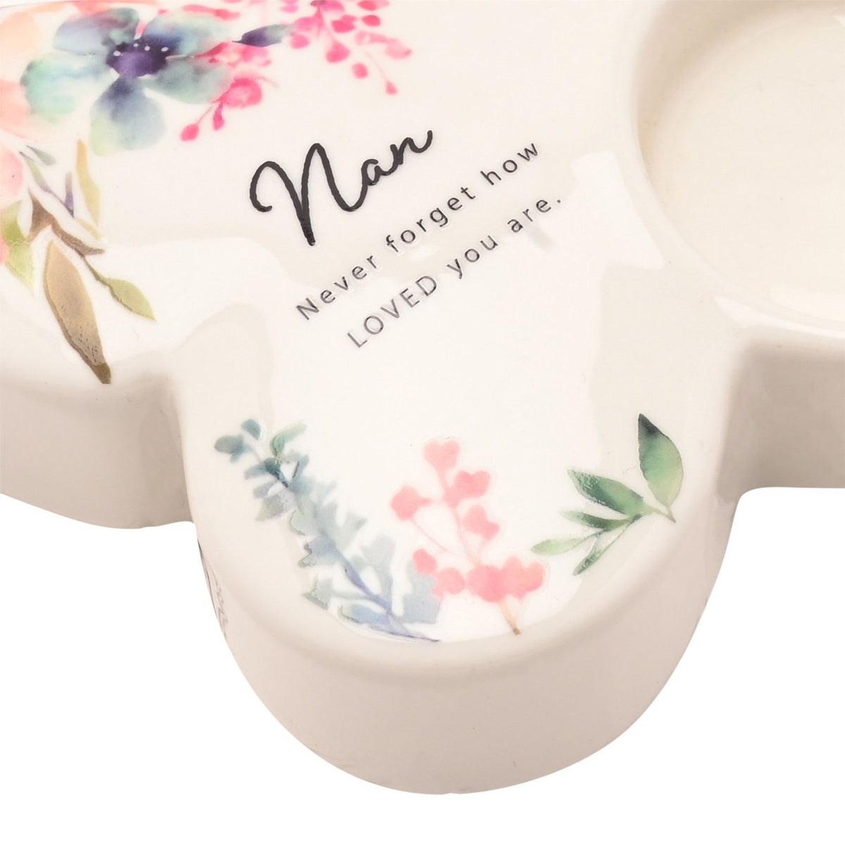 White glass butterfly-shaped tealight holder for Nan, with a round tealight cup, watercolour floral design in pink, lilac and blue, and "Nan, Never forget how LOVED you are" text.