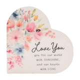 White heart-shaped wooden plaque with a watercolor floral bouquet and bee, reading Love You, you fill our world with SUNSHINE, and our hearts with LOVE.