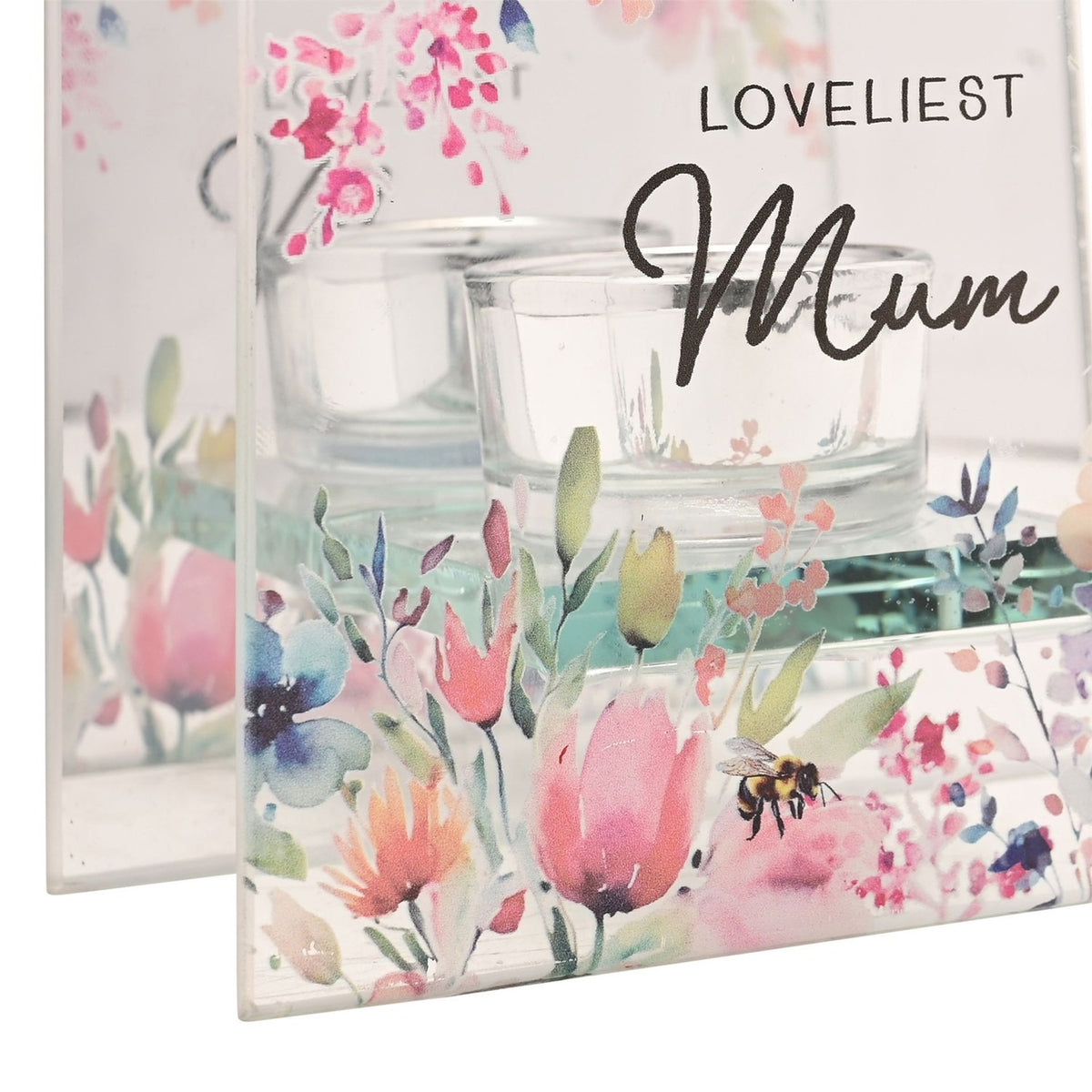 Close-up of the Loveliest Mum glass tealight candle holder, square clear glass panel with pink and blue floral print and a bee, mirrored back panel and glass tealight cups visible.