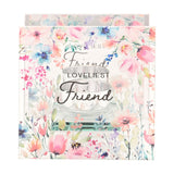 Square clear glass tealight holder printed with Loveliest Friend in script, framed by watercolour wildflowers and a bee, with a round glass cup resting on a narrow ledge.