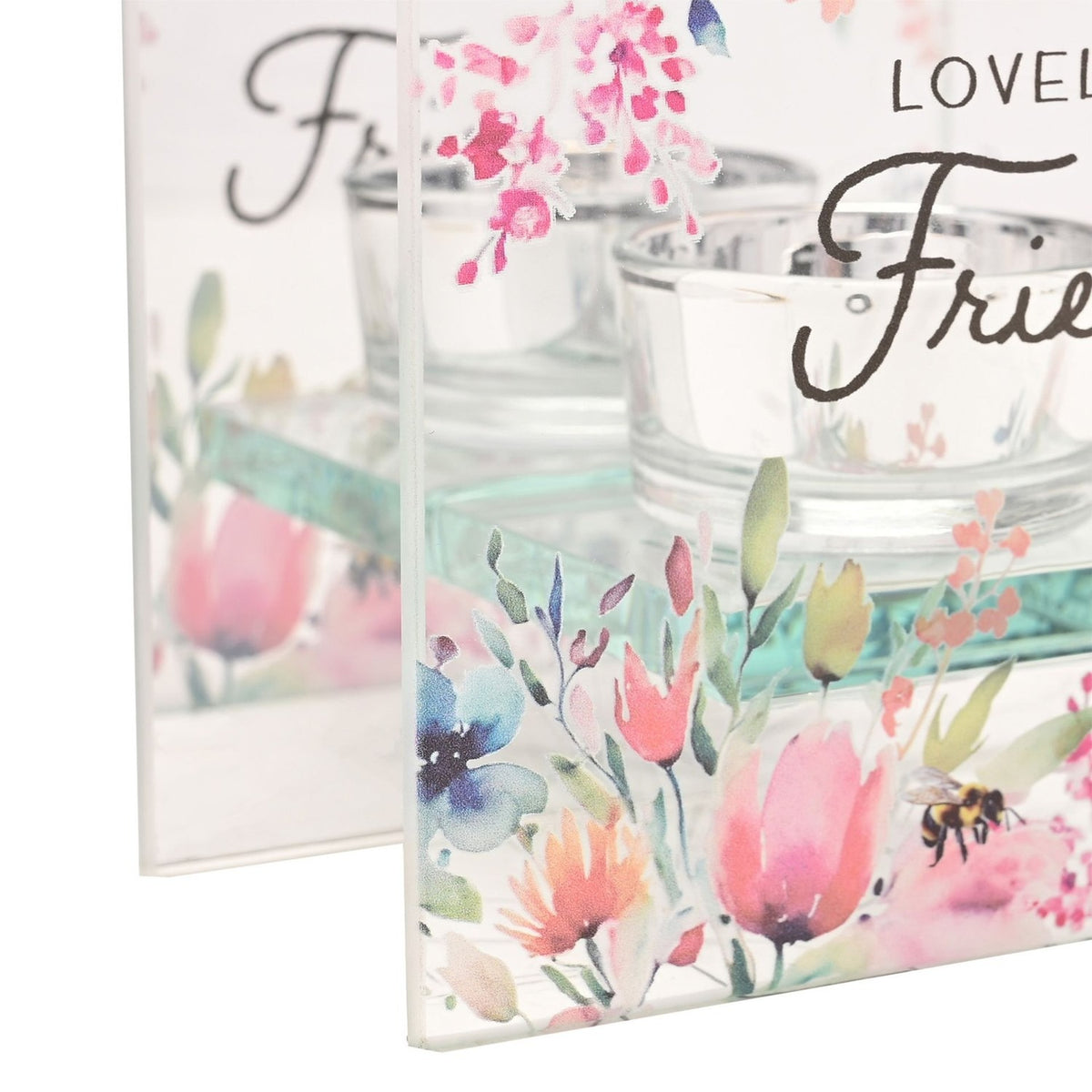 Close-up of the Loveliest Friend square glass tealight candle holder, showing clear glass panels with watercolour floral and bee design and a round tealight cup on a glass ledge.