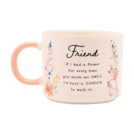 Cream stoneware mug with peach handle, featuring watercolour wildflowers and a "Friend" verse printed in black script, shown on a white background.