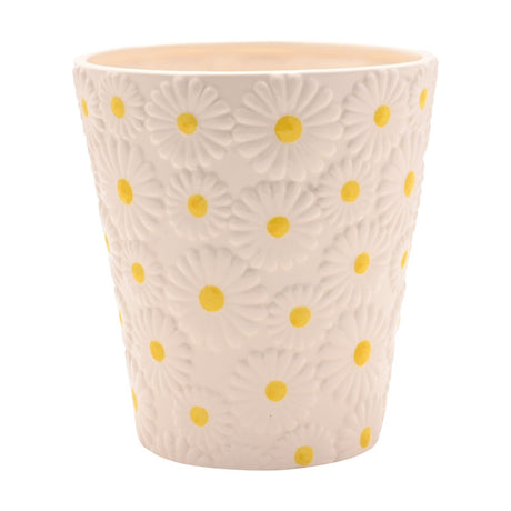 White ceramic planter with raised daisy pattern, each flower featuring a yellow centre, tapering round shape, shown on a plain white background.