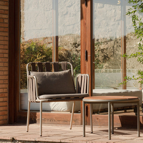 Teja Rope Garden Lounge Chair with woven rope sides and back, grey aluminium frame, grey cushions and matching round side table on a terrace.