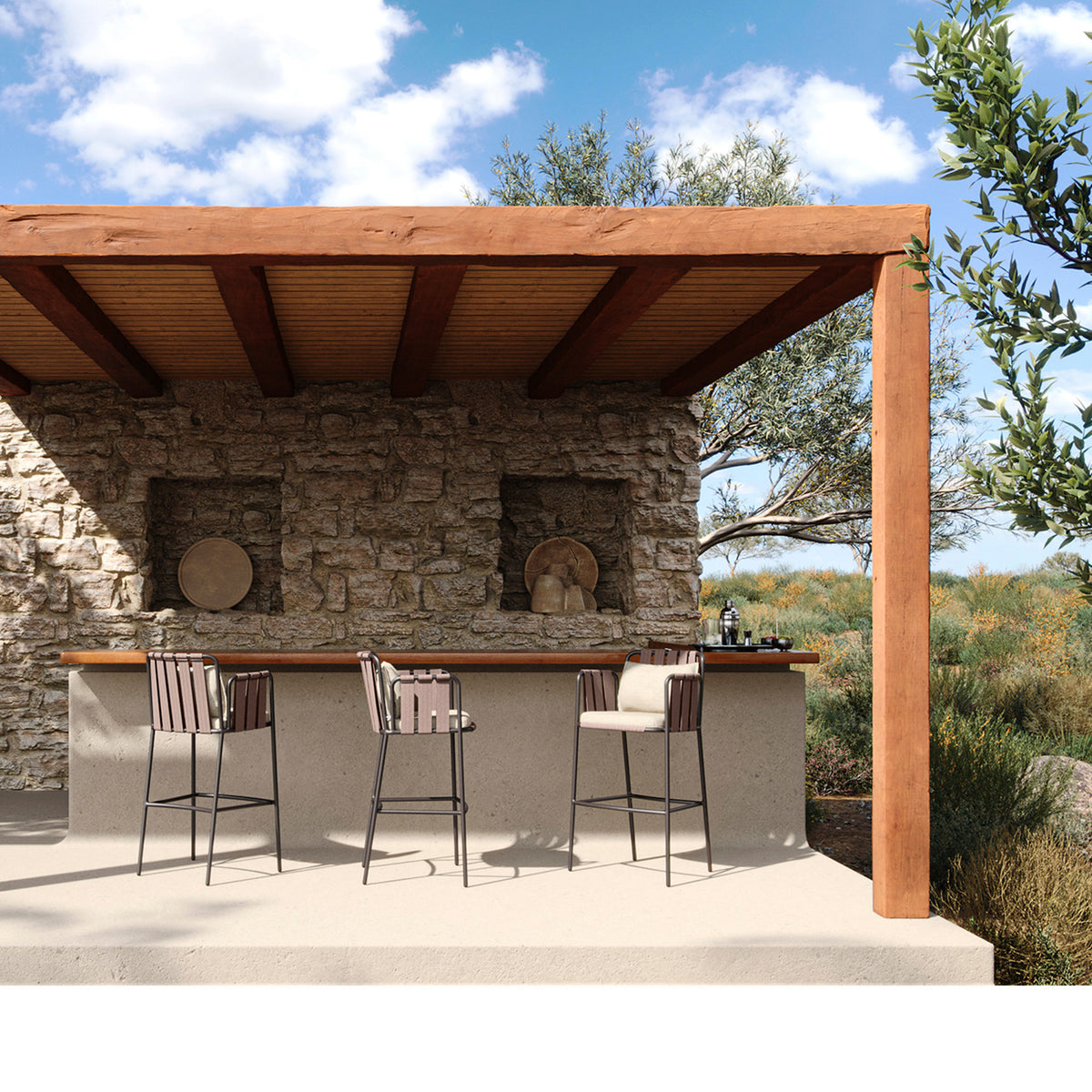Three Teja rope outdoor bar stools with cream seat and back cushions, dark frames, set at a stone bar counter under a wooden pergola.