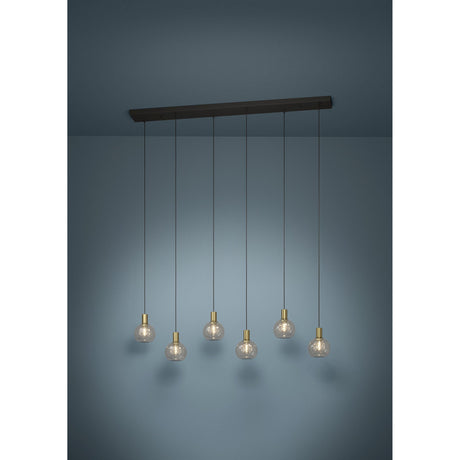 Terque linear pendant light with black ceiling bar, six clear glass globe shades on black cords with brushed brass holders, set against a plain dark background.