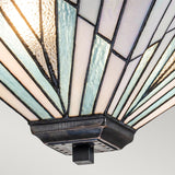 A close-up view of the Alderley 2 Light Trio Mount Tiffany Pendant showcases a stained glass lampshade with geometric patterns in blue, white, and clear glass segments, forming a fan-like shape reminiscent of an Art Deco style. This exquisite design is mounted on a vintage bronze square base.
