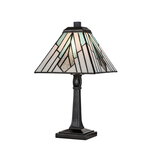 The Alderley 1 Light Medium Table Lamp in vintage bronze showcases a Tiffany-style stained glass shade with geometric patterns in shades of green, white, and brown. Its dark, ornate base adds an elegant touch to any setting.