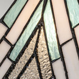 Close-up of the Alderley 1 Light Medium Table Lamp in Vintage Bronze, showcasing a design reminiscent of a stained glass window with Tiffany-style inspiration. The lamp features varied geometric patterns crafted from both textured and smooth glass pieces in shades of white, teal, and clear, all outlined with dark edges.