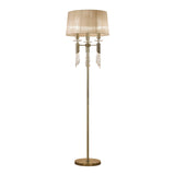The Tiffany 6 Light Crystal Floor Lamp features a brass finish, bronze shade, round base, slender pole, and elegant hanging crystal accents. When lit, it emits a warm, inviting light perfect for any space.