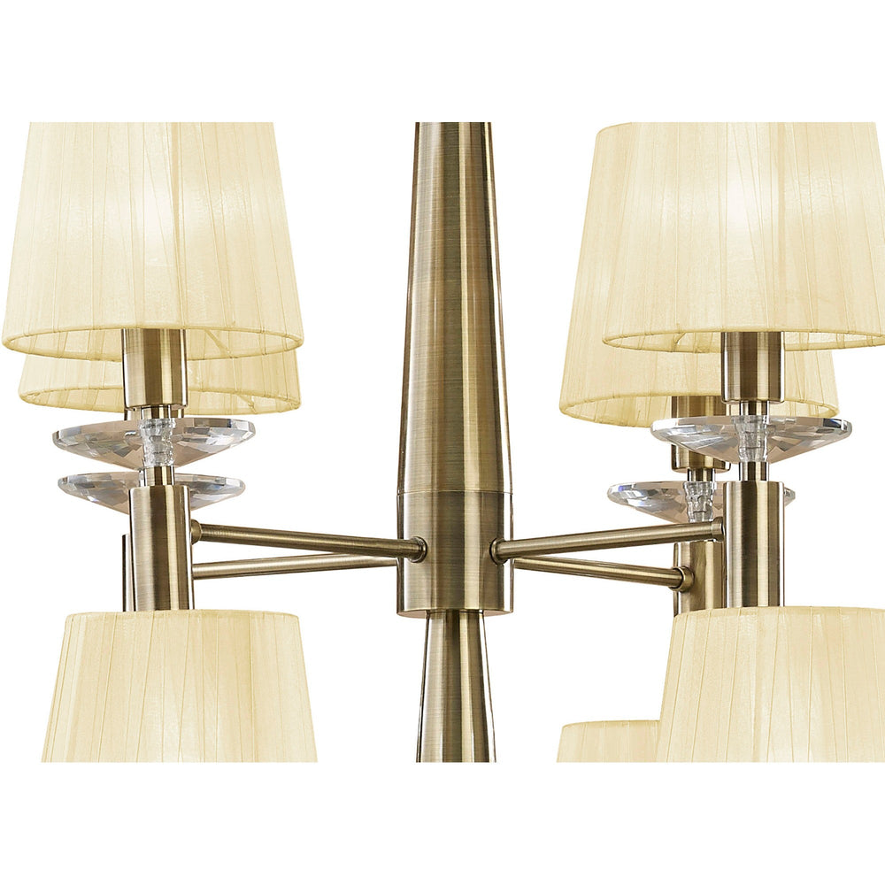 Close-up of Tiffany 12 Light 2 Tier Chandelier showing antique brass arms, cream pleated fabric shades, and faceted crystal accents.
