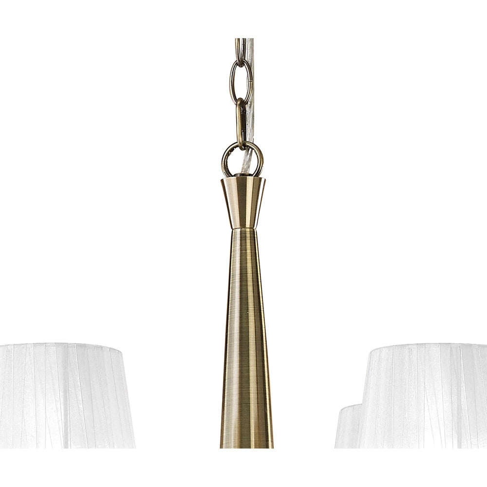Close-up of the Tiffany chandelier's antique brass central column and chain suspension, with the tops of two white pleated fabric shades visible.
