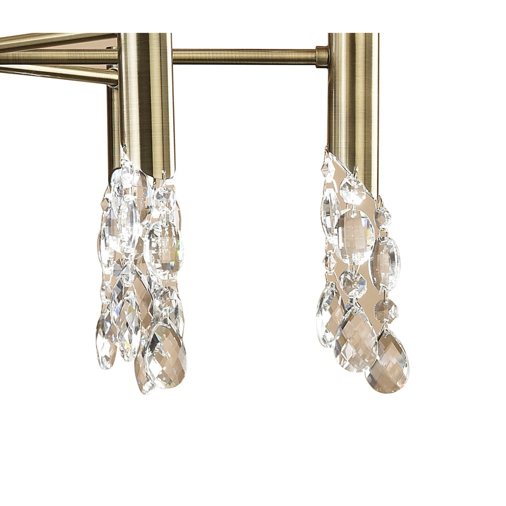 Close-up of Tiffany chandelier detail showing antique brass arms with suspended faceted crystal droplet clusters against a white background.