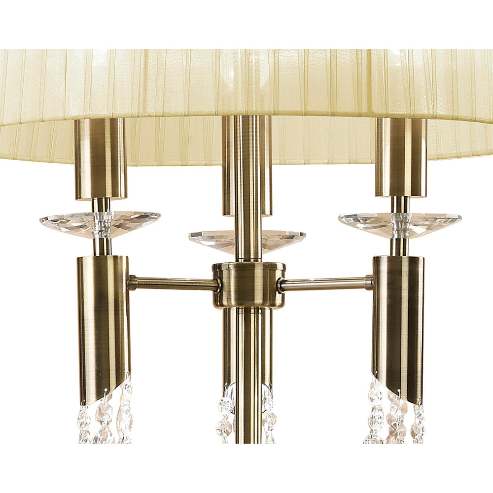 Close-up of the Tiffany 3 Light Crystal Floor Lamp in brass, featuring a cream pleated shade and crystal accents, with six candle-style lights elegantly arranged around a central metallic rod.
