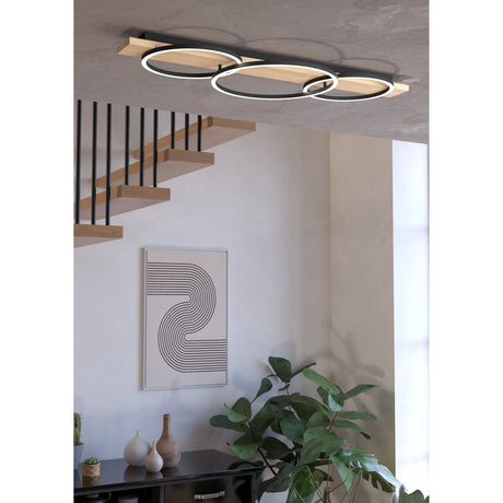 Timarne LED 3 Light Flush Ceiling Light, black rings with white diffusers on a black and brown wooden bar, shown mounted in a hallway above a staircase.