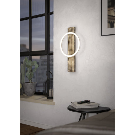 Timarne LED wall light with a rustic brown wood plank and illuminated black-rimmed ring, mounted beside a window in a living room setting.