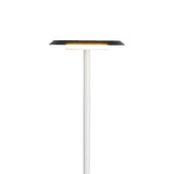 The Tina LED Floor Lamp 12W 3000K in white and black features a slim white stand and a flat, circular black shade, casting soft ambient lighting against a plain white background.