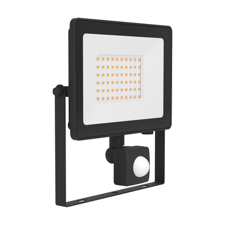 Tirnine LED flood light in black aluminium with clear glass front, integrated LED panel, wall-mounting bracket and motion sensor beneath the head, shown on a plain white background.