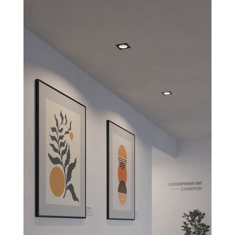 Square black recessed LED downlights, Tomelle 9.3 x 9.3cm, installed in a hallway ceiling above framed botanical artwork near a gallery exhibition sign.