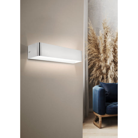 Tomessa LED wall light, 36.5cm rectangular satin nickel bar with white diffuser underside, mounted on a beige wall near a living room chair and dried foliage.