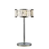 The Torre 3 Light Crystal Table Lamp features a polished chrome round base and stem, topped with a cylindrical shade made of vertical clear crystal panels that partially reveal the bulbs inside.