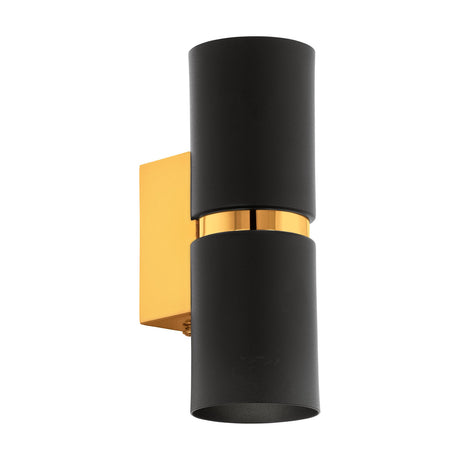Tramena Wall Light 6cm in matt black steel with two cylinder shades joined by a polished gold band on a gold rectangular backplate, shown on a plain white background.
